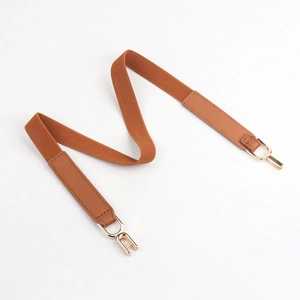 Detailed macro of brown elastic waist belt with gold hook buckle and faux leather patches