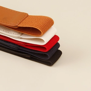 Macro shot of colorful elastic waist belts showcasing woven texture and leather ends