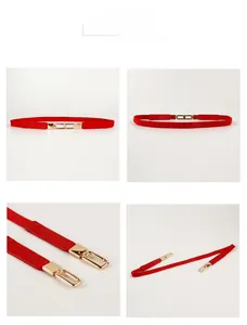 Detail of red thin leather belt featuring a minimalist rectangular gold metal buckle