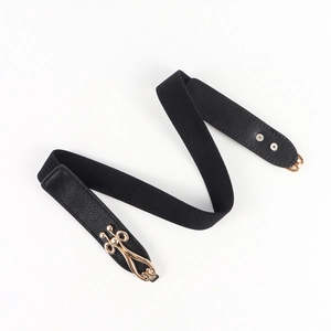 Detail of black elastic waist belt with gold hollow buckle and lychee texture faux leather