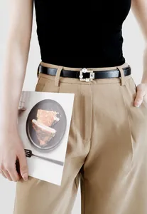 Detail of elegant black PU leather thin belt featuring a square pearl and rhinestone buckle