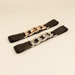 Détail de ceintures élastiques noires avec grosses boucles de chaîne en or et argent