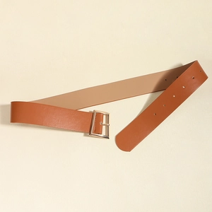Gros plan sur une large ceinture en cuir PU marron avec boucle carrée en métal doré