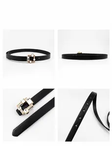 Detailed macro view of the black slim leather belt with a golden rhinestone square buckle