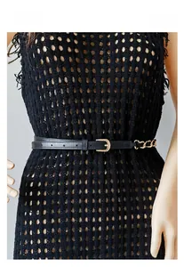 Détail d'une fine ceinture noire avec décoration de chaîne dorée sur robe