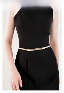 Detail shot of a sleek gold rectangular buckle on a slim metal waist chain for dresses