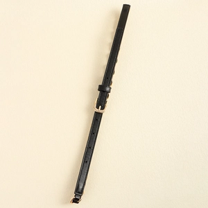 Détail d'une ceinture noire en cuir avec boucle dorée polie et trous de réglage fins