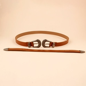 Détail de la ceinture en cuir marron avec double boucles ciselées en argent vieilli