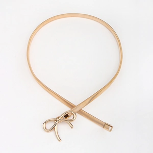 Detail of elegant gold metal bow buckle and elastic spring chain belt for women