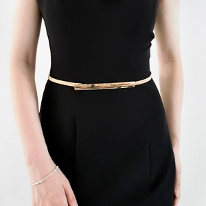 Elegant gold metal waist chain with minimalist rectangular buckle on a black dress