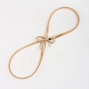 Detail view of the fine spiral spring structure and golden bow buckle on the metal waist chain