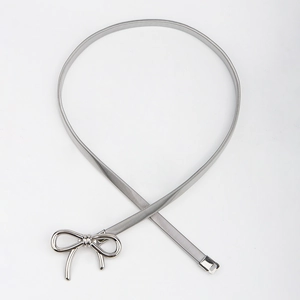 Detailed macro view of the silver bow buckle and elastic metal chain on the waist belt