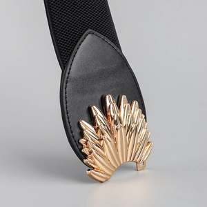 Detail of a gold feather buckle with black elastic fabric on a women's waist belt