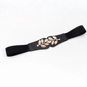 Detalle de cinturón elástico de mujer con hebilla decorativa de hoja metálica