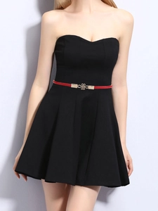 Detail of red PU leather skinny belt with a golden hollow knot buckle on black dress