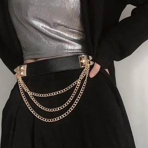 Close-up of black leather belt featuring triple layered gold chains and square metal studs