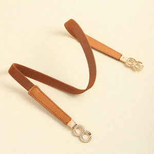 Detail of a brown elastic waist belt with a golden textured interlocking buckle design
