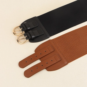 Detail view of wide elastic belts in black and brown with double-buckle gold metal hardware