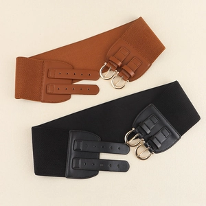 Detail of wide elastic waist belts in brown and black with double golden metal buckles