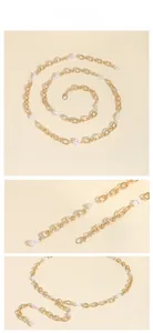 Close-up of golden metal chain belt featuring irregular white baroque pearls and lobster clasp