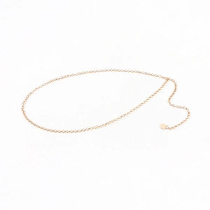 Vue détaillée d'une chaîne de taille dorée minimaliste avec un petit pendentif rond