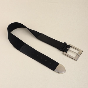 Detail of black elastic belt featuring a silver rectangular buckle and polished metal tip