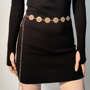 Close-up of golden metal waist chain with vintage textured discs on black dress