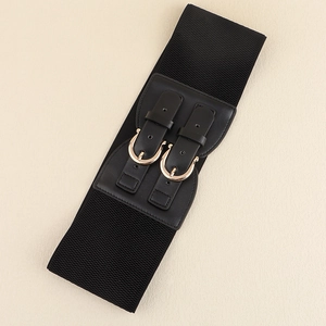 Detail shot of wide black elastic waist belt with dual golden buckles and leather trim