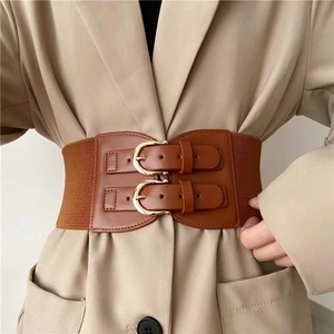 Brown elastic wide cinch belt with golden double pin buckles on a beige suit