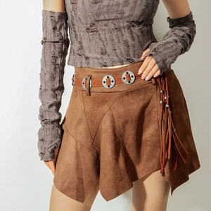 Detail eines braunen Wildlederrocks im Boho-Stil mit Fransen und Metallnieten am Gürtel