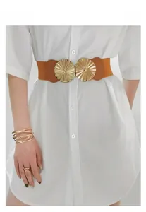 Détail d'une ceinture large élastique marron avec boucle soleil dorée sur chemise