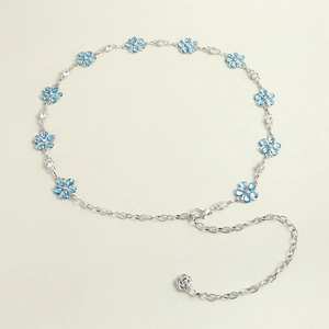 Detailed macro view of silver chain belt featuring blue floral charms and crystal accents