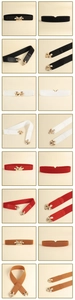 Close-up of golden hollow clover buckle and elastic waist belt texture detail