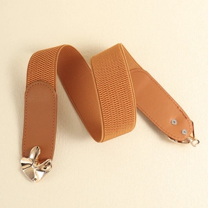 Detail of camel elastic belt with golden wavy buckle and premium faux leather stitching