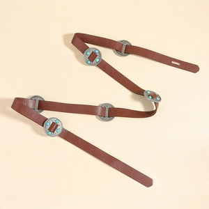 Détail d'une ceinture bohème en cuir marron avec disques en métal argenté et perles de turquoise