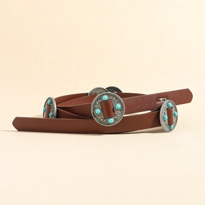 Détail d'une ceinture bohème en cuir avec plaques argentées gravées et perles turquoise