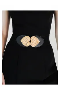 Detail of a black elastic waist belt featuring a gold double heart buckle with textures