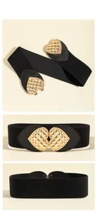 Close-up of black elastic waist belt with gold heart buckle and textured metal finish