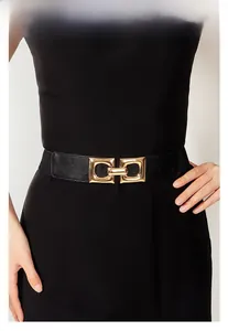 Detail of black leather waist belt with textured finish and interlocking gold metal buckle
