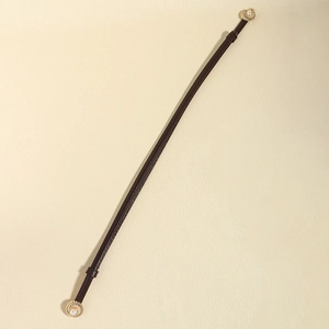Detail of slim dark brown leather belt featuring elegant gold vintage pearl buckles
