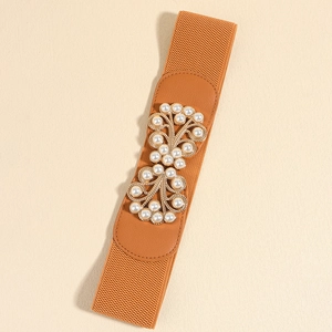 Close-up of camel elastic waist belt with gold pearl buckle on textured background