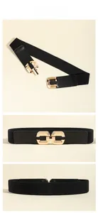 Detail view of black elastic waist belt with gold interlocking metal buckle and leather ends