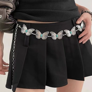 Detailed view of silver butterfly waist chain with turquoise stones on black dress