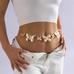 Detailed close-up of gold metal butterfly waist chain on a white outfit