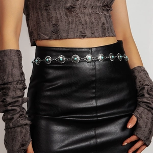 Detail of vintage bohemian silver waist chain with turquoise stones on a black skirt