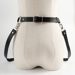 Detail of black PU leather body harness with silver metal chains and punk style buckles