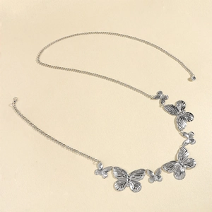 Detail showing vintage silver butterfly waist chain with textured metallic pendants