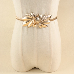 Macro shot of gold leaf buckle and elastic snake bone metal belt for dresses