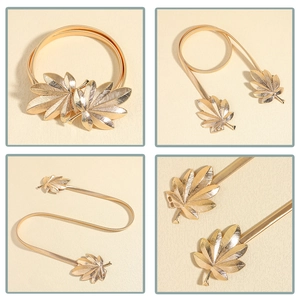 Detail view of golden maple leaf buckle and elastic snake chain metal waist belt for dresses