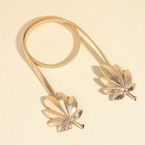 Detail of golden maple leaf buckle and stretch metal chain for waist belt